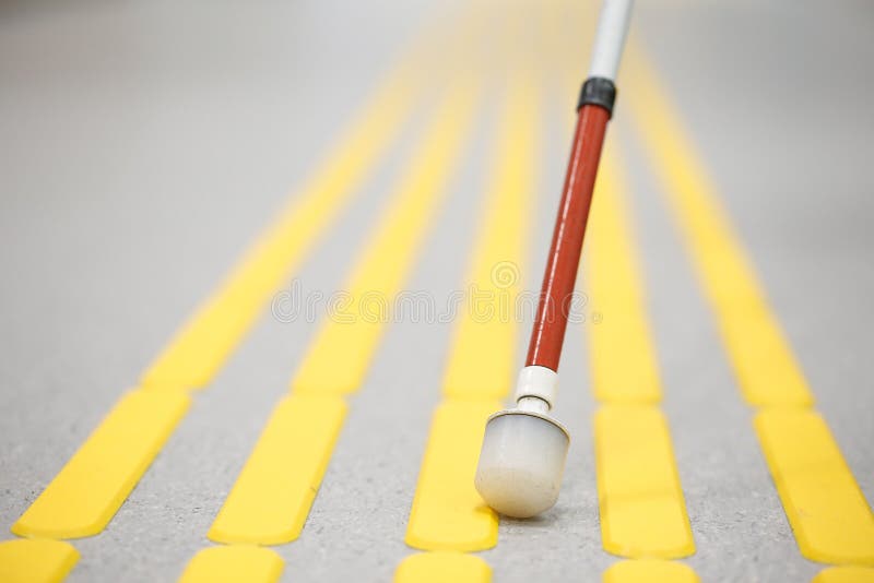 Blind pedestrian walking on tactile paving
