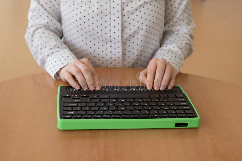 A Blind Woman Uses a Computer with a Braille Display and a Computer