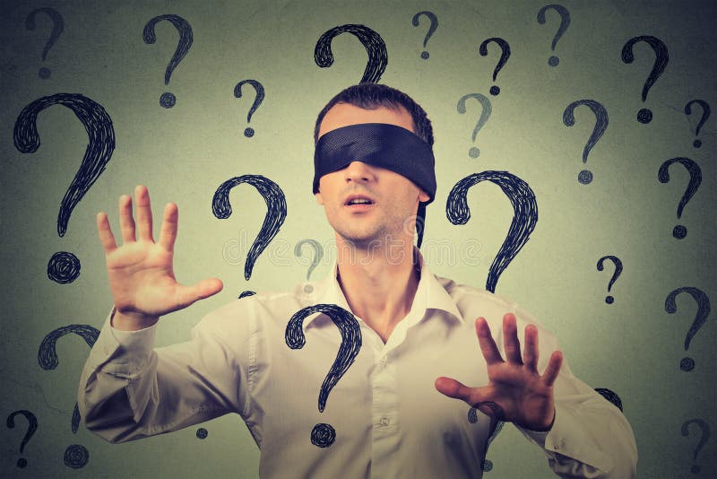 Blindfolded man stretching his arms out walking through many question marks