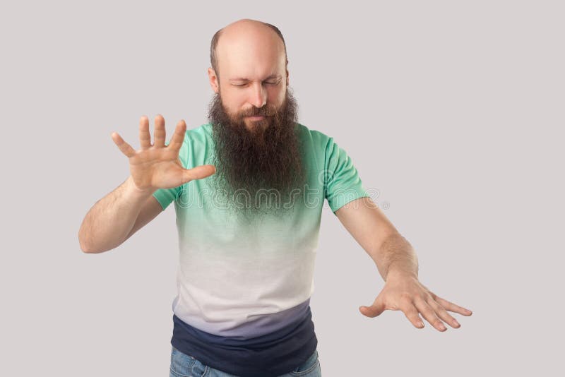 Blindheit. Porträt von mittelalten kahlen Mann mit Bart in hellgrünen T-Shirt stehen mit geschlossenen Augen und versuchen, zu ber