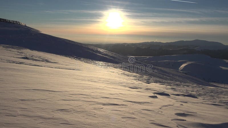 Blizzard en las montañas al atardecer, vista invernal, paisaje alpino, estación de esquí