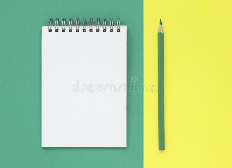 Bloc-notes vide ouvert avec un crayon vert, sur un vert et un fond étendu plat jaune Avec l'espace de copie images stock Bloc-notes vide ouvert avec un crayon vert, sur un vert et un fond étendu plat jaune Avec l'espace de copie images stock