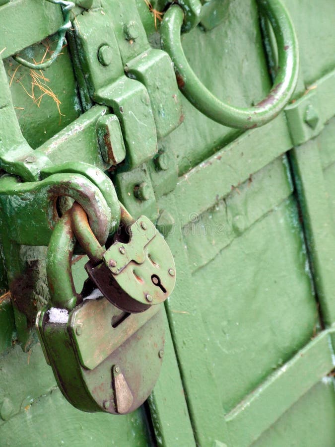 A close shot of two locks, small one and large one, hanging on a green steel door. Can be used to express security, safety, etc. A close shot of two locks, small one and large one, hanging on a green steel door. Can be used to express security, safety, etc.