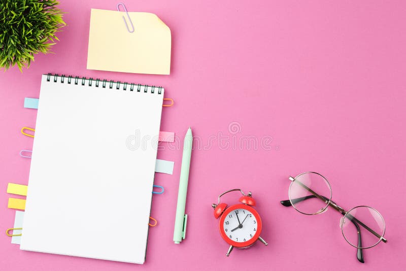 Blocco note aperto con orologio di allarme. fotografia stock