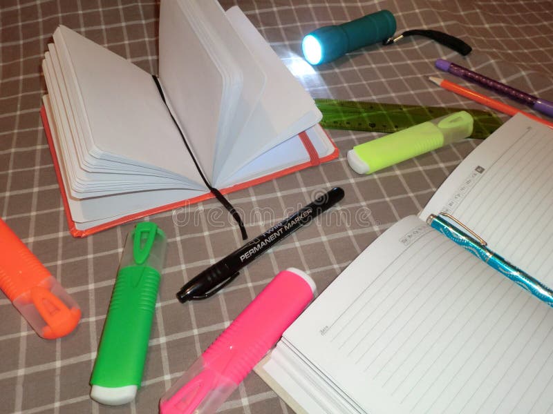 Blocco note del modello, diario con la penna, matita, righello, indicatori e una torcia elettrica fotografia stock