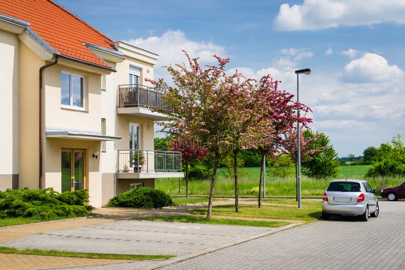 Block of flats in green nature with car parked