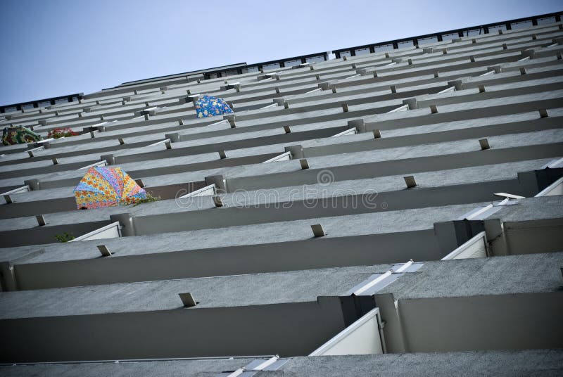 Block of flats and umbrellas on the balconies on summer hot day