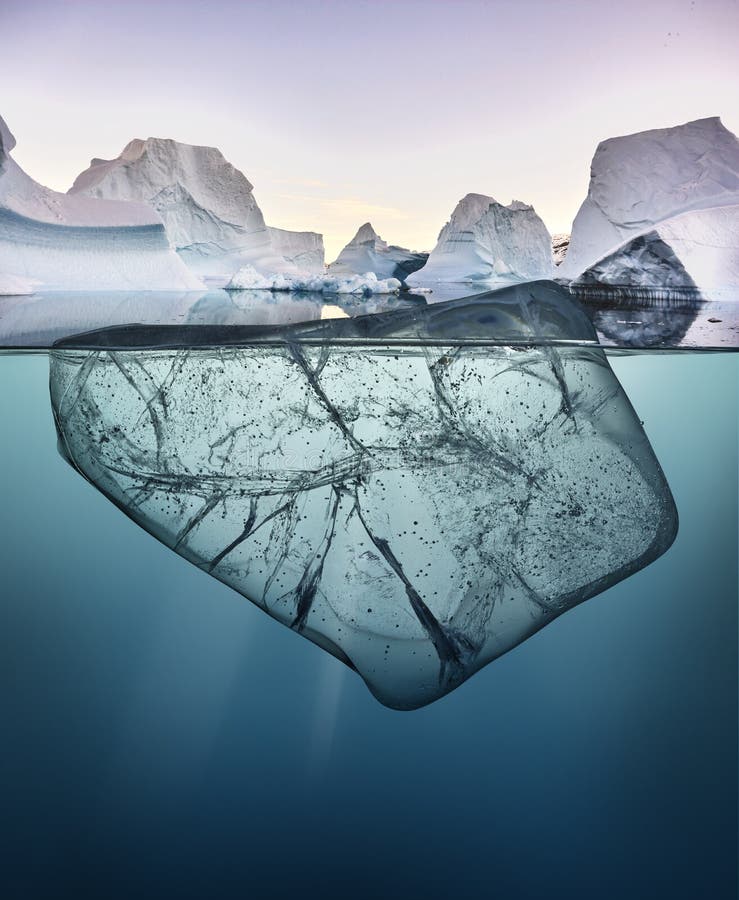 Block of Ice with Underwater View and Greenland Background. Stock Photo