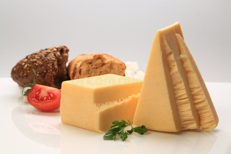 Block and Triangle Sliced Cheese with a Slice of Tomato Stock Photo