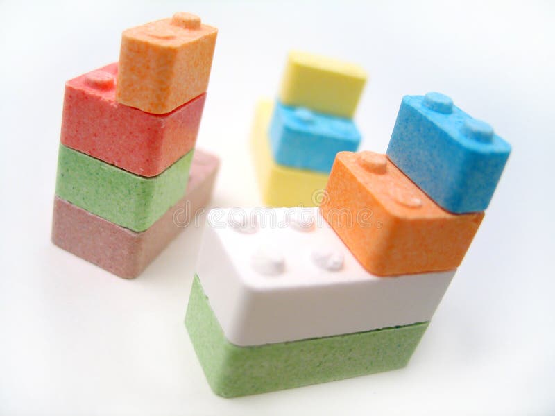 Colored candy blocks scattered on white background. Focus on front blocks. Colored candy blocks scattered on white background. Focus on front blocks.