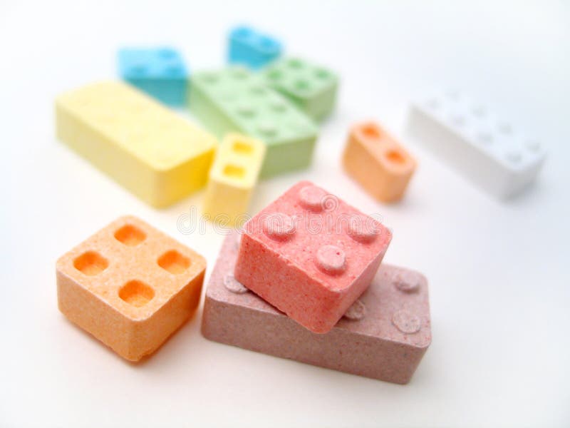 Colored candy blocks scattered on white background. Focus on front blocks. Colored candy blocks scattered on white background. Focus on front blocks.