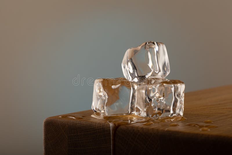 Square melting ice cubes on wet table Stock Photo by FabrikaPhoto