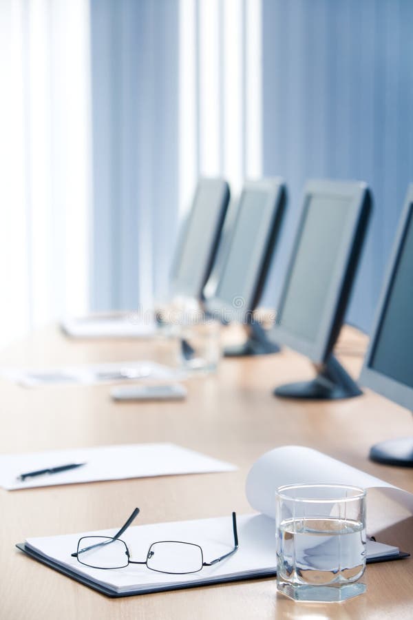 Vertical image of notepad with eye glasses on it and glass of water near by. Vertical image of notepad with eye glasses on it and glass of water near by