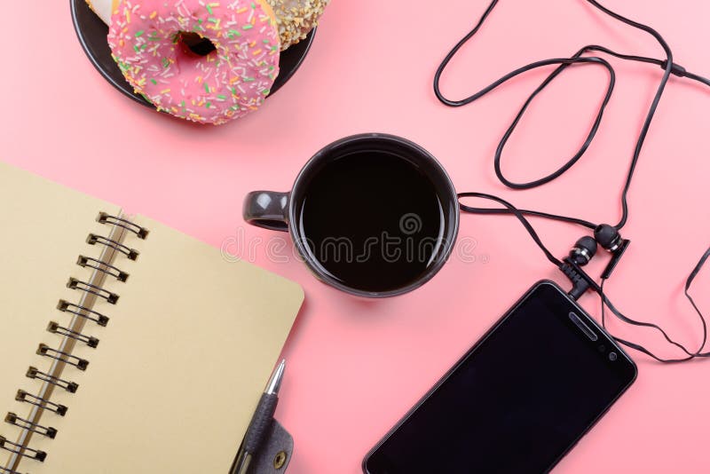 Blocnote op de lentes, een kop van koffie en een telefoon met hoofdtelefoons op een heldere roze achtergrond Plaats voor tekst he stock afbeeldingen Blocnote op de lentes, een kop van koffie en een telefoon met hoofdtelefoons op een heldere roze achtergrond Plaats voor tekst he stock afbeeldingen