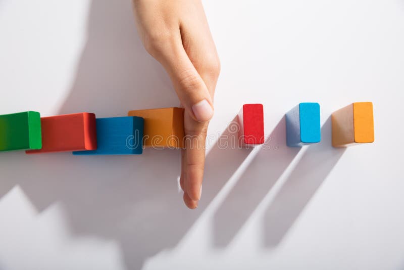 Blocos de Hand Stopping Colorful do empresário da queda imagem de stock royalty free Blocos de Hand Stopping Colorful do empresário da queda imagem de stock royalty free