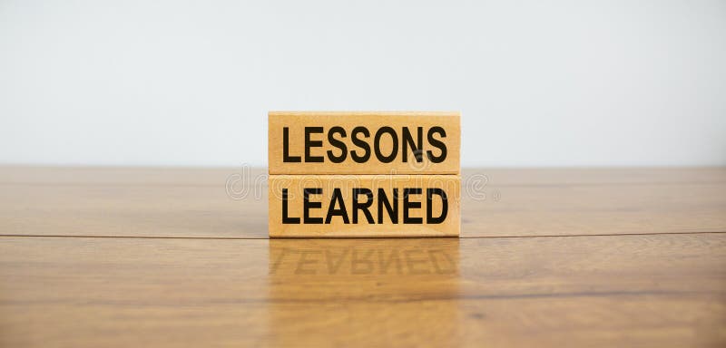 Wooden blocks form the text `lessons learned` on beautiful wooden table, white background. Business concept, copy space. Wooden blocks form the text `lessons learned` on beautiful wooden table, white background. Business concept, copy space.