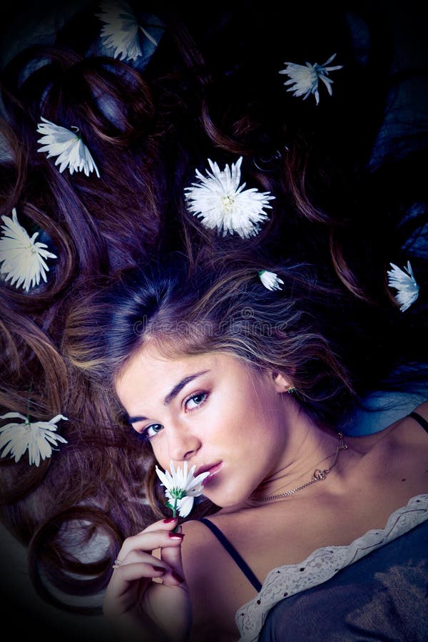 Lying young beautiful woman with flowers in her long hair. Lying young beautiful woman with flowers in her long hair