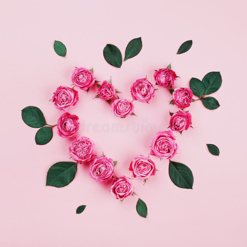 Bloemendiehart van roze roze bloemen en groene bladeren op pastelkleur hoogste mening als achtergrond wordt gemaakt Vlak leg het royalty-vrije stock fotografie Bloemendiehart van roze roze bloemen en groene bladeren op pastelkleur hoogste mening als achtergrond wordt gemaakt Vlak leg het royalty-vrije stock fotografie