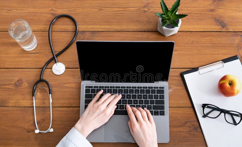 Blog and online doctor consultation. Female hands in a white coat on laptop