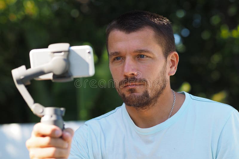 Blogger male with three-axis electronic stabilizer gimbal. royalty free stock images