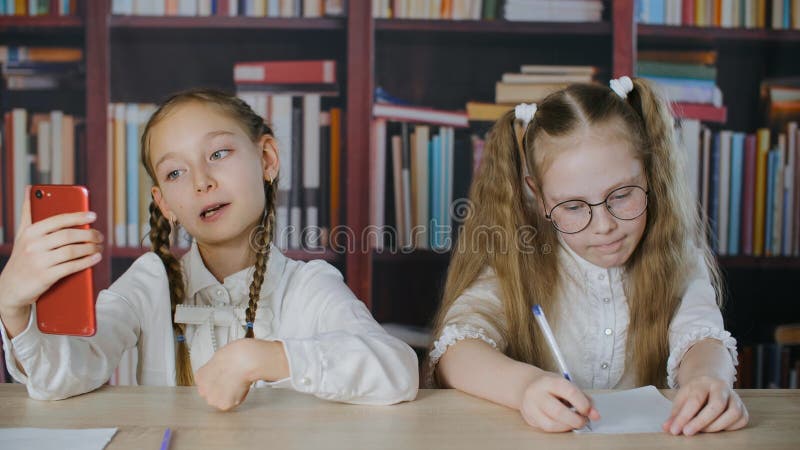 Bloggermädchenschießen selfie Video zum Handy im Schulklassenzimmer Jugendlichmädchenschießen-Live-Übertragung mit