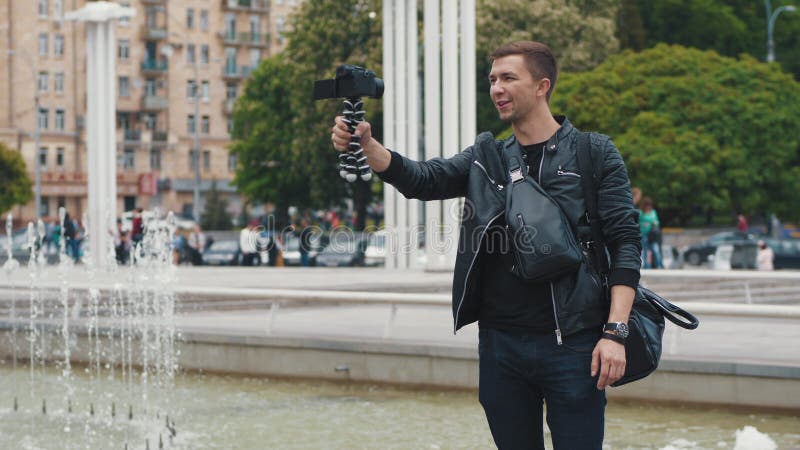 Blogue video de transmiss?o do blogger masculino novo de uma rua da cidade