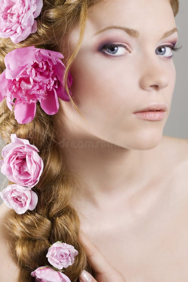 Portrait of young woman with with braids and flowers in hair. Portrait of young woman with with braids and flowers in hair