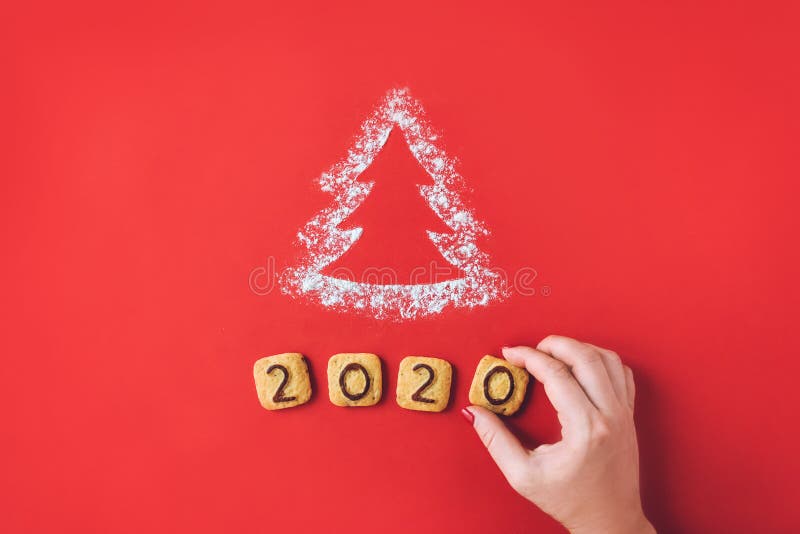 Flour Silhouette Christmas Tree with cookies digits 2020 on red background with women hand. Delicious bakery sweet confectionery Christmas card. Idea of merry new year xmas 2020 holiday, female, date, happy, art, bright, brown, celebrations, decor, decoration, festive, holidays, number, objects, old, ornaments, retro, seasons, set, sigh, sign, star, style, symbol, texture, twine, vintage, winter, wooden. Flour Silhouette Christmas Tree with cookies digits 2020 on red background with women hand. Delicious bakery sweet confectionery Christmas card. Idea of merry new year xmas 2020 holiday, female, date, happy, art, bright, brown, celebrations, decor, decoration, festive, holidays, number, objects, old, ornaments, retro, seasons, set, sigh, sign, star, style, symbol, texture, twine, vintage, winter, wooden