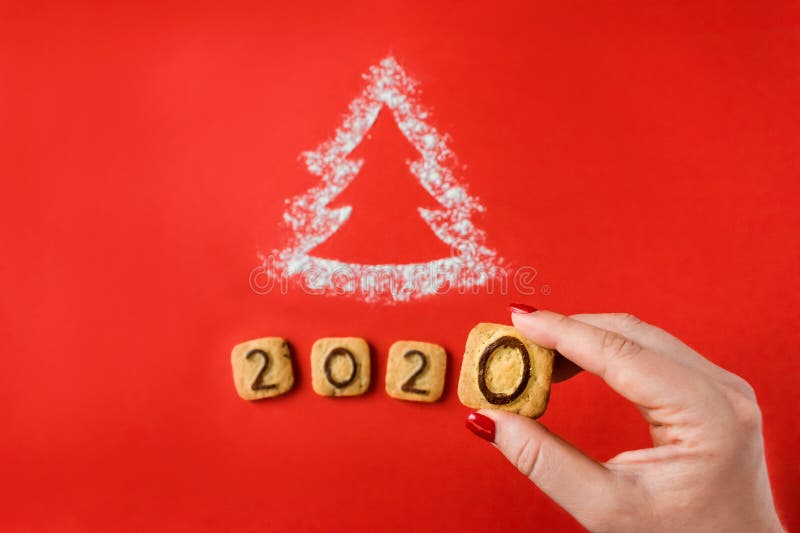 Flour Silhouette Christmas Tree with cookies digits 2020 on red background with women hand. Delicious bakery sweet confectionery Christmas card. Idea of merry new year xmas 2020 holiday, female, date, happy, art, bright, brown, celebrations, decor, decoration, festive, holidays, number, objects, old, ornaments, retro, seasons, set, sigh, sign, star, style, symbol, texture, twine, vintage, winter, wooden. Flour Silhouette Christmas Tree with cookies digits 2020 on red background with women hand. Delicious bakery sweet confectionery Christmas card. Idea of merry new year xmas 2020 holiday, female, date, happy, art, bright, brown, celebrations, decor, decoration, festive, holidays, number, objects, old, ornaments, retro, seasons, set, sigh, sign, star, style, symbol, texture, twine, vintage, winter, wooden