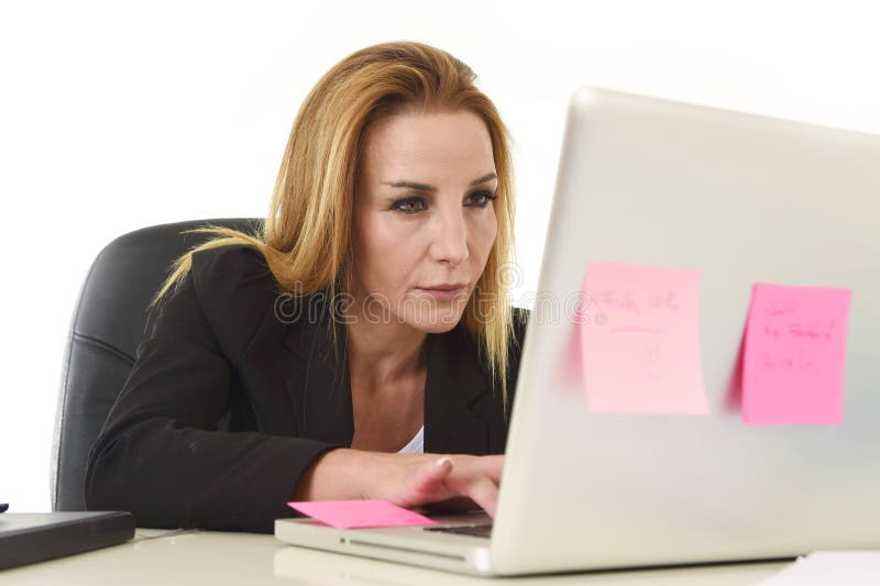 Blond attractive 40s woman in business suit working at laptop computer