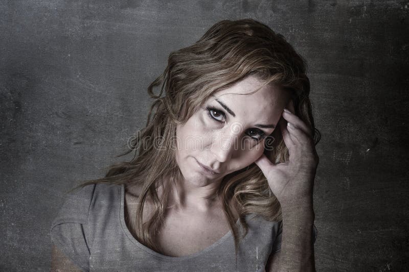 Blond attractive woman on her thirties sad and depressed looking at the camera in sorrow and grief