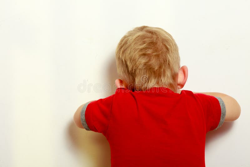 Happy childhood. Back view. Blond boy child covering his face. Kid preschooler playing hide-and-seek or blind man's buff. Indoor. Happy childhood. Back view. Blond boy child covering his face. Kid preschooler playing hide-and-seek or blind man's buff. Indoor.