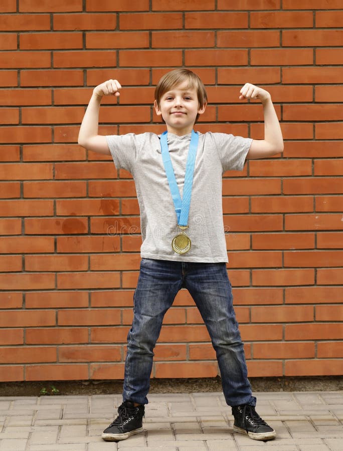 Blond boy is happy gold medal - champion. Athlete, holding.