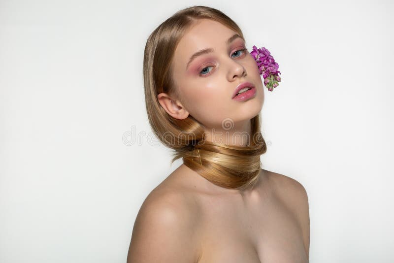 Blond flicka f?r ?lskv?rd ton?ring med bl?a ?gon, perfekt hud och kala skuldror Hennes hals sl?s in i h?r, purpurf?rgad sommar royaltyfri bild Blond flicka f?r ?lskv?rd ton?ring med bl?a ?gon, perfekt hud och kala skuldror Hennes hals sl?s in i h?r, purpurf?rgad sommar royaltyfri bild