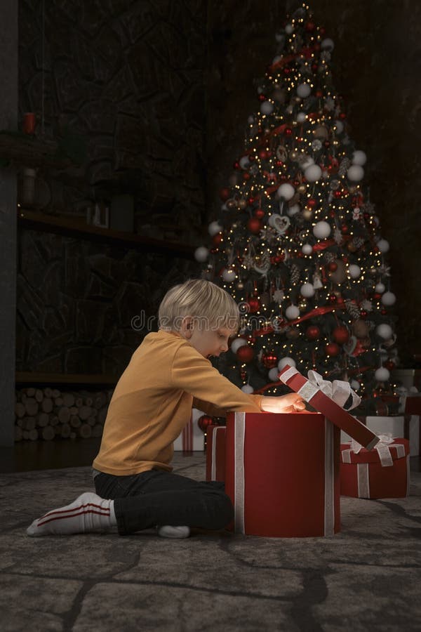Blond garçon ouvert Noël présent. bébé surpris et joyeux avec de grands cadeaux xmas. cadre vertical photo stock