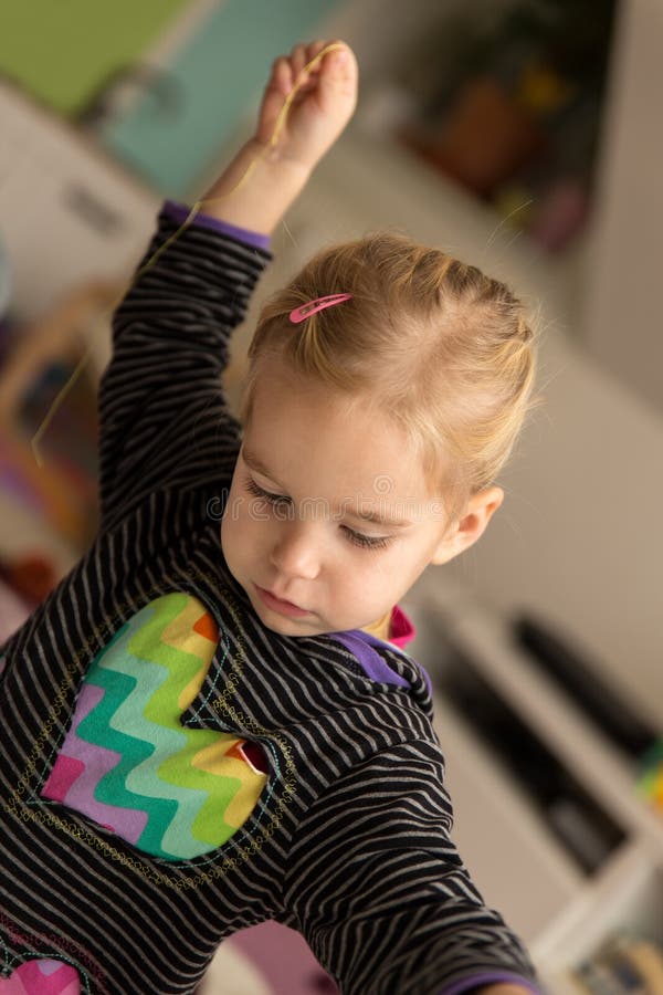 Blond girl is playing with sewing cotton stock image Blond girl is playing with sewing cotton stock image