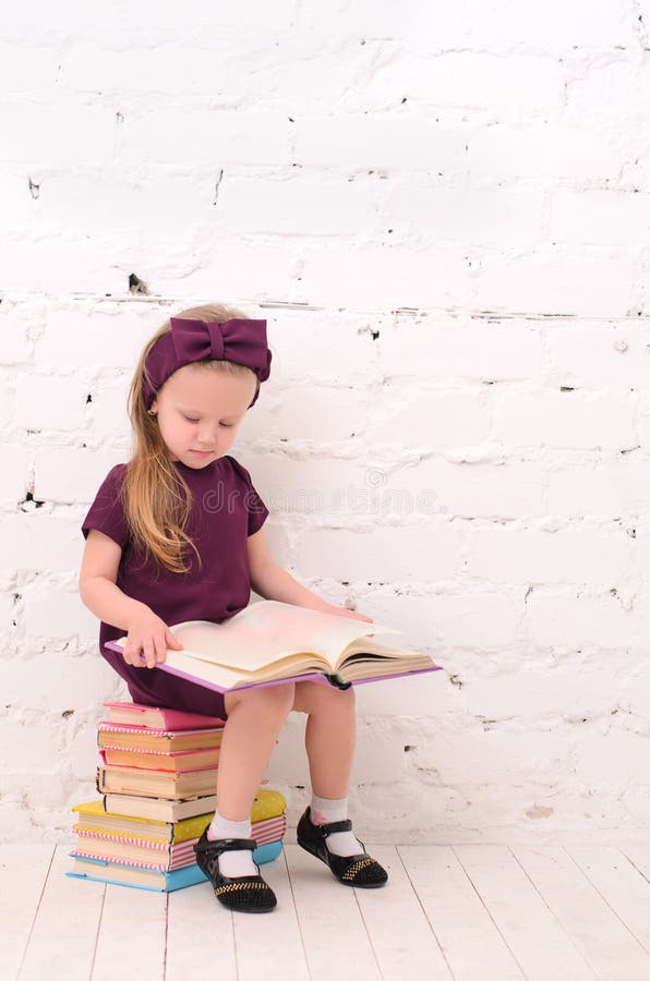 blond girl sitting on a pile of books royalty free stock images blond girl sitting on a pile of books royalty free stock images
