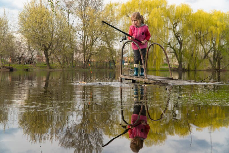 Blond kid girl fishing tuna little tunny happy with trolling catch on boat deck royalty free stock photography Blond kid girl fishing tuna little tunny happy with trolling catch on boat deck royalty free stock photography