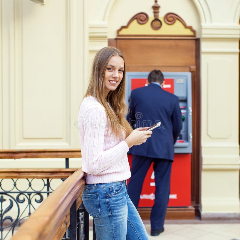 Blond kvinna på bakgrunden i köpcentret ATM royaltyfri bild Blond kvinna på bakgrunden i köpcentret ATM royaltyfri bild