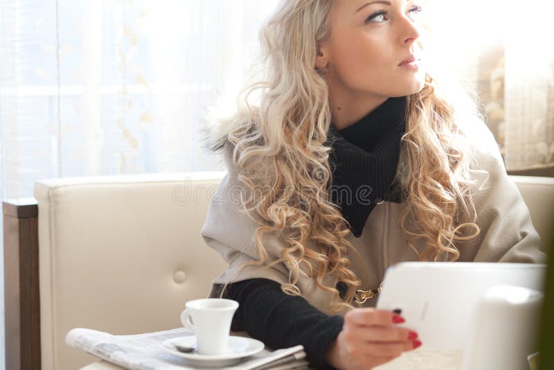 Blond kvinnaläsning på en minnestavla arkivbild Blond kvinnaläsning på en minnestavla arkivbild