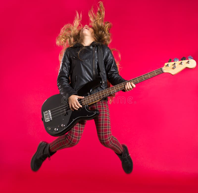 Blond Rock and roll girl with bass guitar jump on red royalty free stock images Blond Rock and roll girl with bass guitar jump on red royalty free stock images