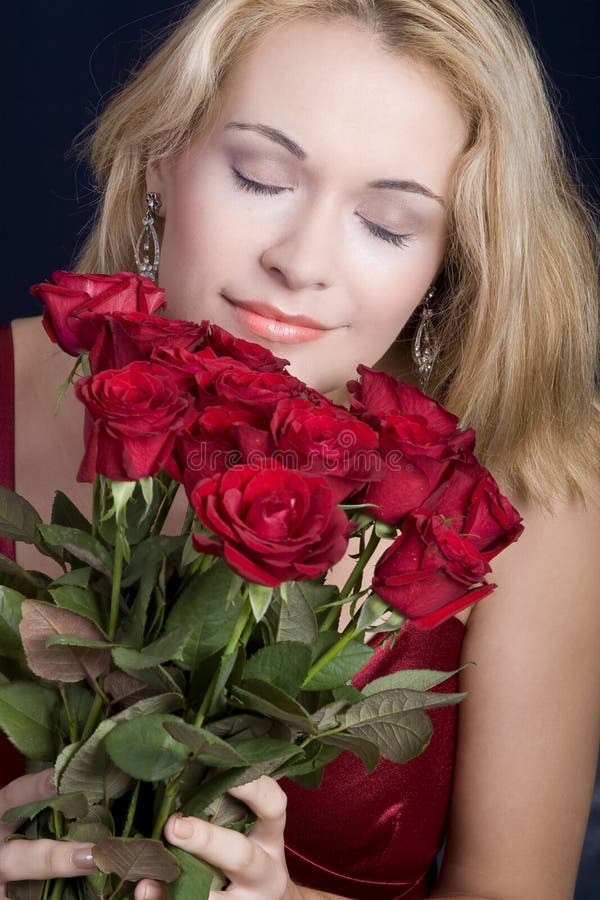 Blond smelling roses