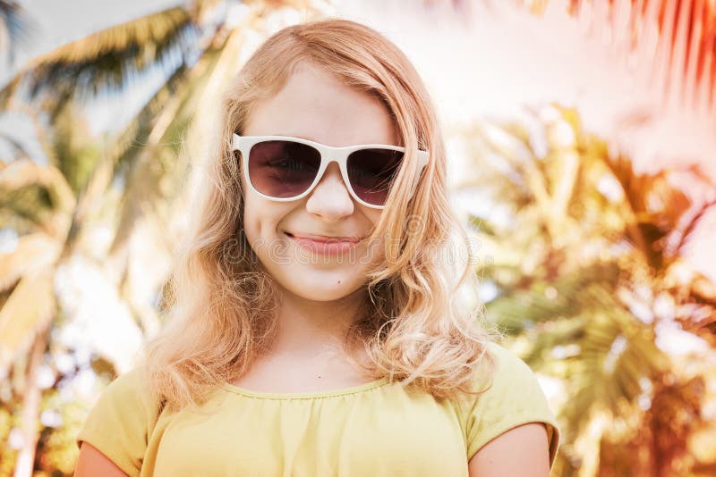 Blond smiling teenager girl in sunglasses, toned photo