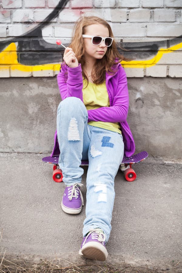 Blond teenager girl with lollipop, vertical urban outdoor portra