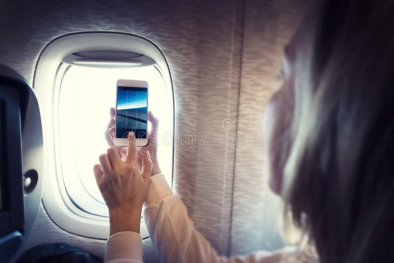 Blond, ung kvinna filmar video med smartphone arkivfoto