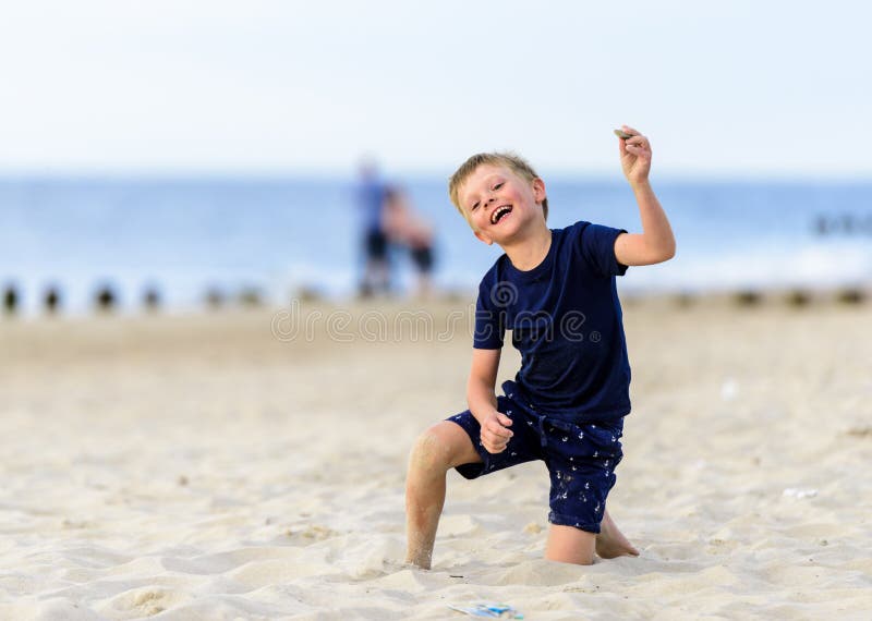 Blond ung pojke som tycker om en strand arkivfoton Blond ung pojke som tycker om en strand arkivfoton