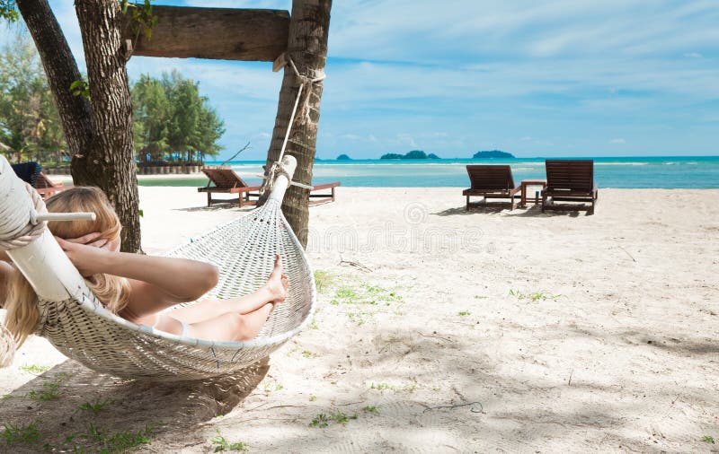 Blond woman asleep in a hammock.