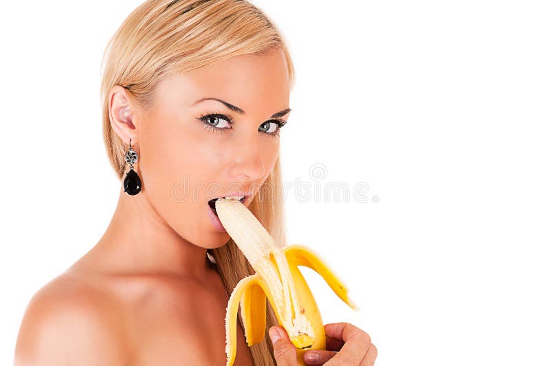 Blond woman eats banana stock photo