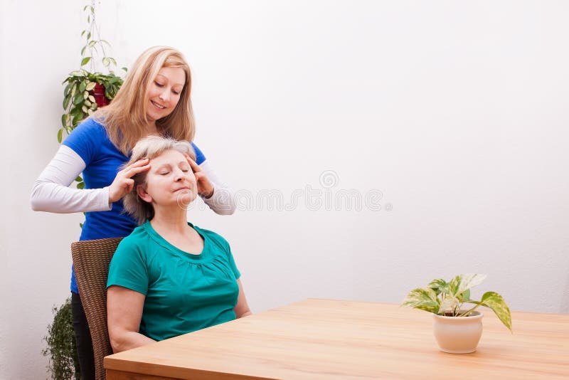 Pretty Young women massaging female seniors scalp. Pretty Young women massaging female seniors scalp