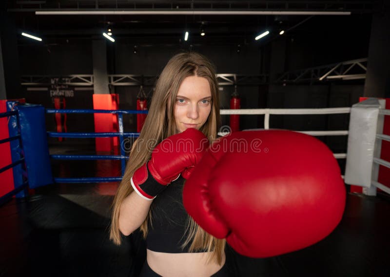 Blonde Caucasian Fighter Girl In Red Boxing Gloves Is Posing On Fight Club Boxing Ring Stock